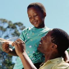 Father and son playing with paper airplane